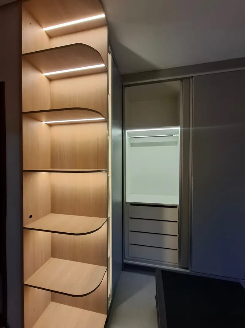 Closet planejado com prateleiras curvas e iluminação em LED