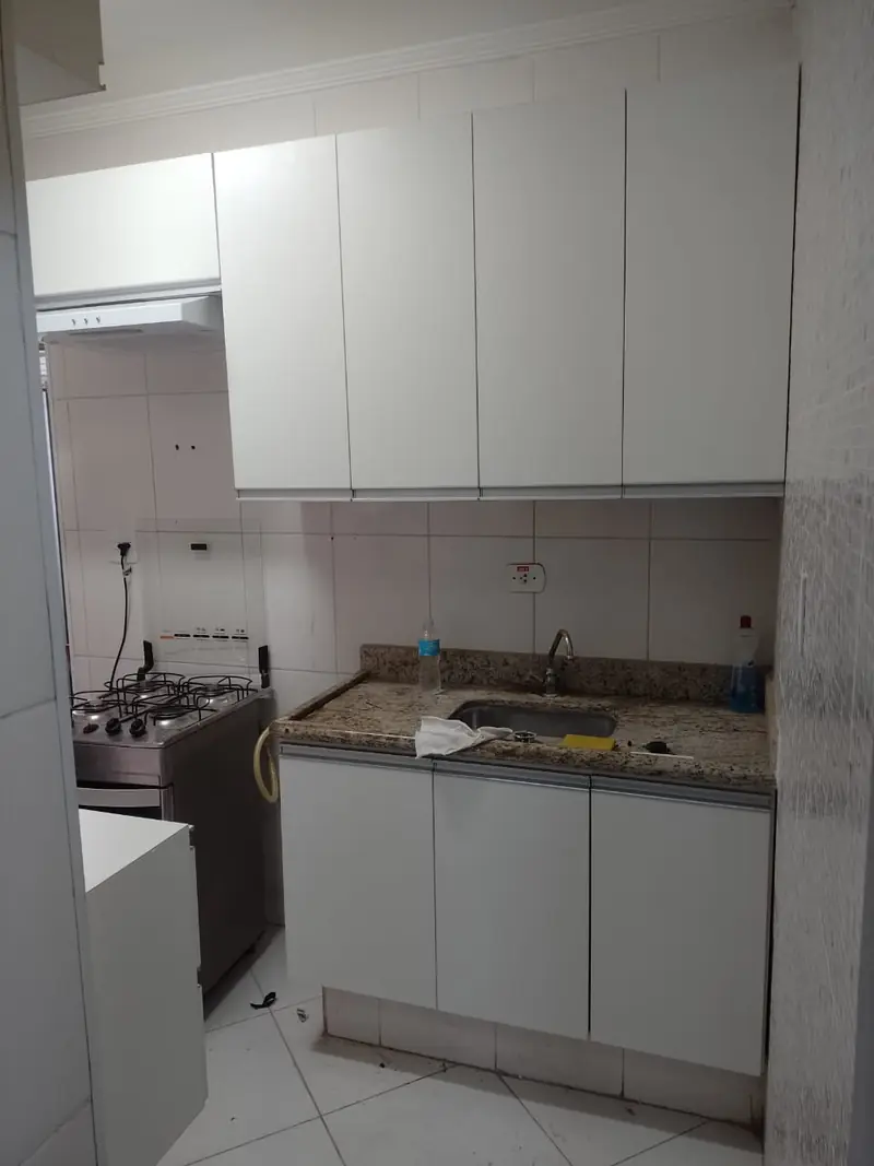 Cozinha planejada branca com armários até o teto e bancada em granito
