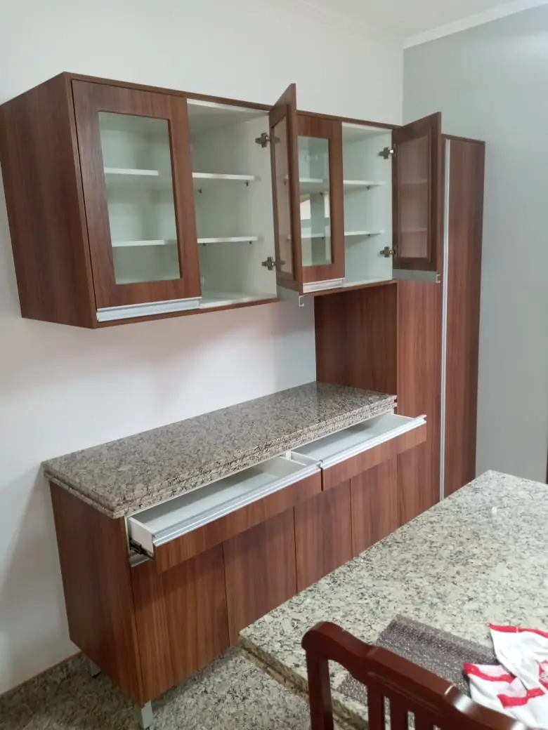 Armários aéreos com portas de vidro e bancada em granito