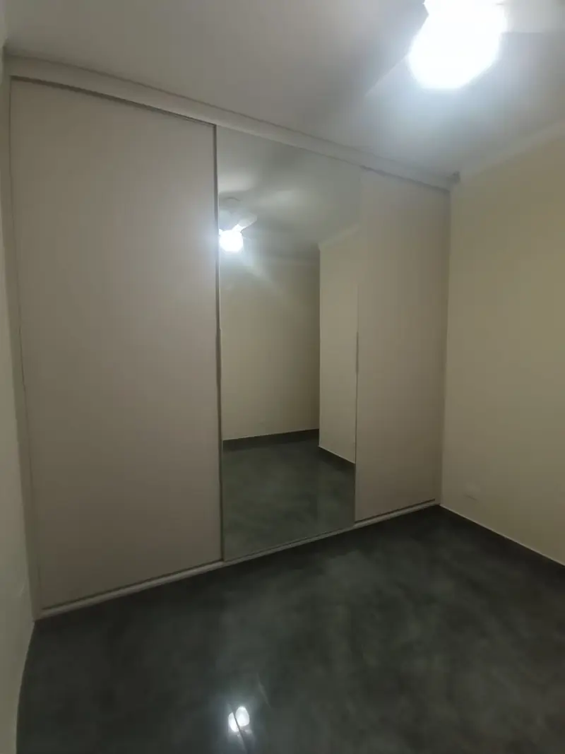 Roupeiro planejado branco ocupando a parede inteira