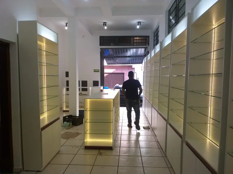 Loja de cosméticos com expositores iluminados dos dois lados