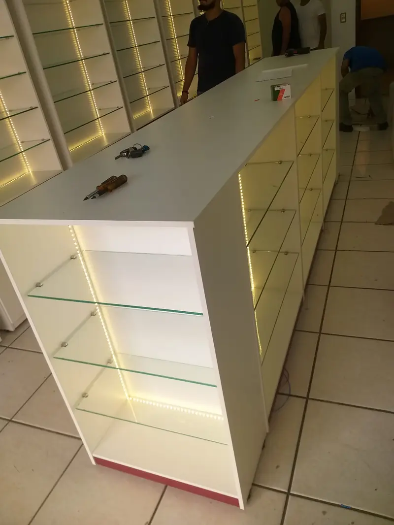 Balcão de caixa com vitrine de vidro e prateleiras