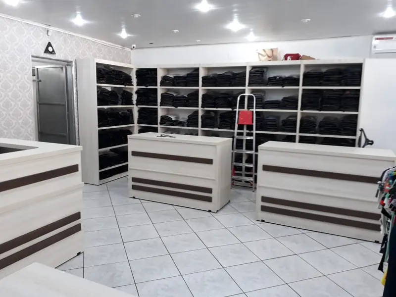 Salão de loja de roupas com balcão central planejado